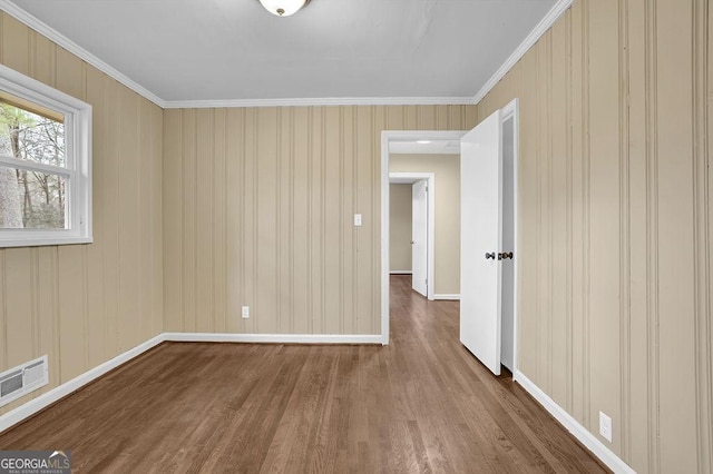 unfurnished room with hardwood / wood-style flooring and ornamental molding