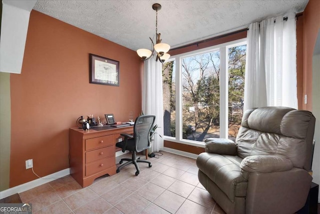 tiled home office featuring a chandelier, a textured ceiling, and a wealth of natural light