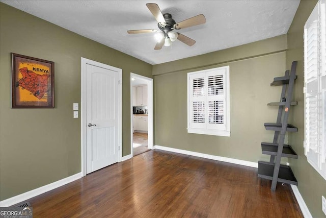 empty room featuring ceiling fan and dark hardwood / wood-style floors