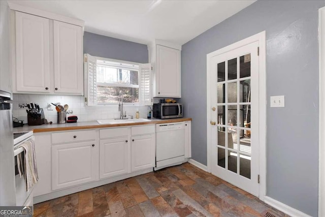 kitchen with backsplash, white appliances, sink, and white cabinets