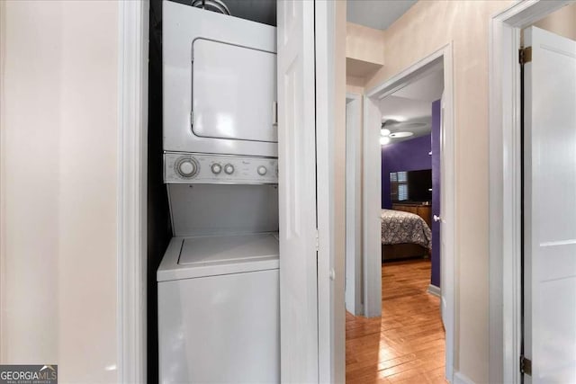 laundry area featuring stacked washer / dryer and hardwood / wood-style floors