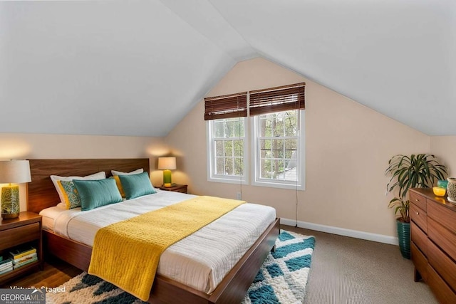 carpeted bedroom with lofted ceiling