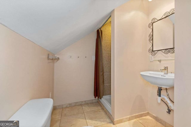 bathroom featuring lofted ceiling, sink, tile patterned flooring, walk in shower, and toilet