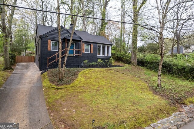 2597 Elsinore St, East Point, GA 30344 - view of front of house with a front lawn, fence, driveway, and a chimney
