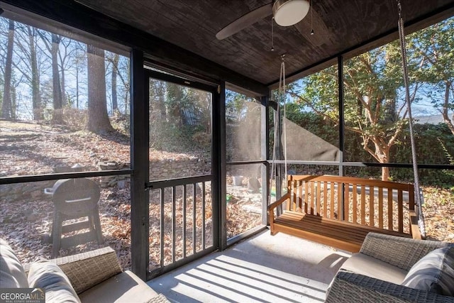 sunroom / solarium with ceiling fan, plenty of natural light, and wood ceiling