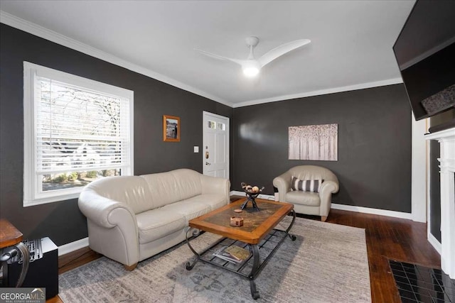 living room with dark wood-type flooring, ornamental molding, and ceiling fan