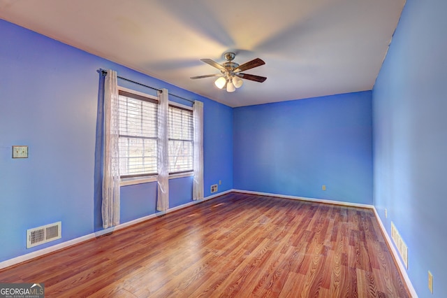 empty room featuring hardwood / wood-style flooring and ceiling fan