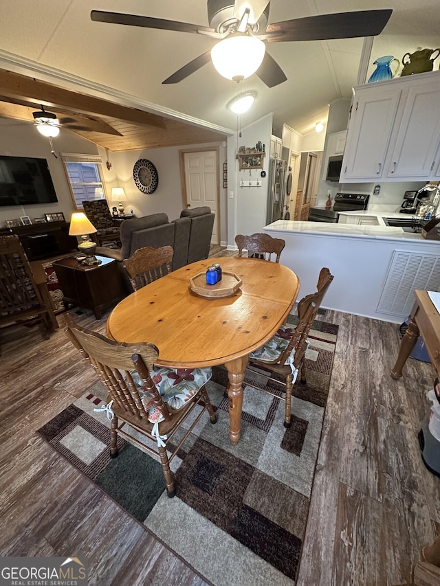 dining space featuring ceiling fan, lofted ceiling, and dark hardwood / wood-style flooring