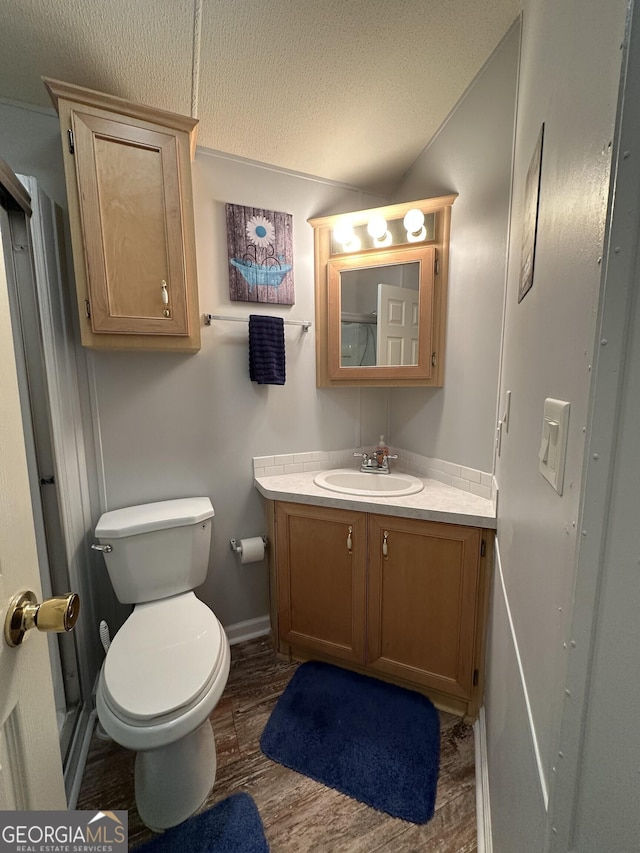 bathroom featuring wood-type flooring, vanity, and toilet