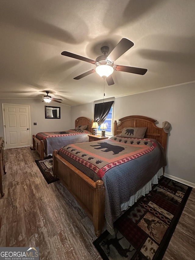 bedroom with dark hardwood / wood-style floors and ceiling fan