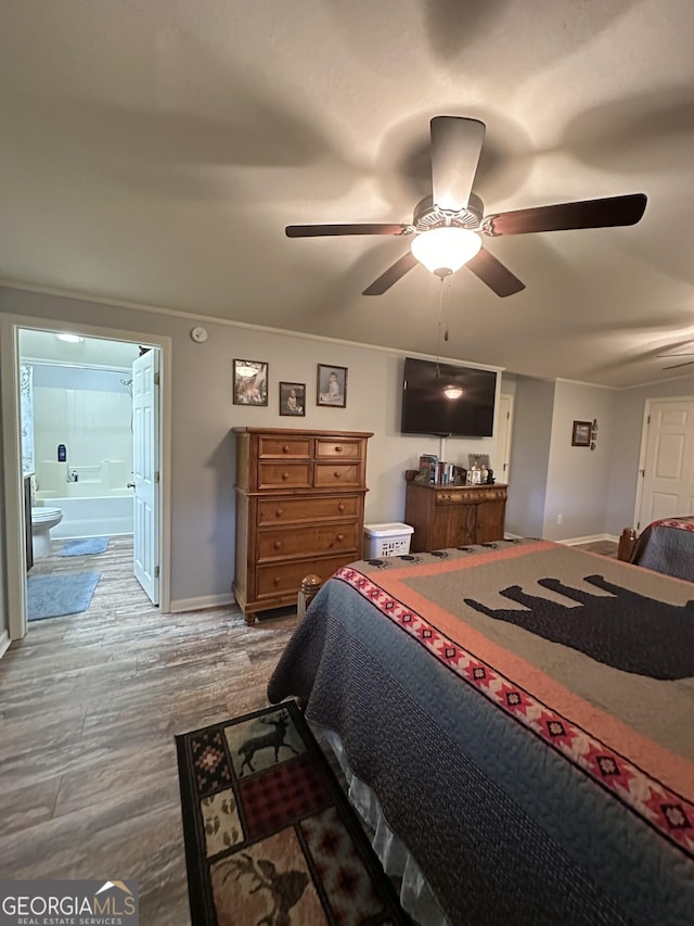 bedroom with hardwood / wood-style flooring, ceiling fan, and connected bathroom