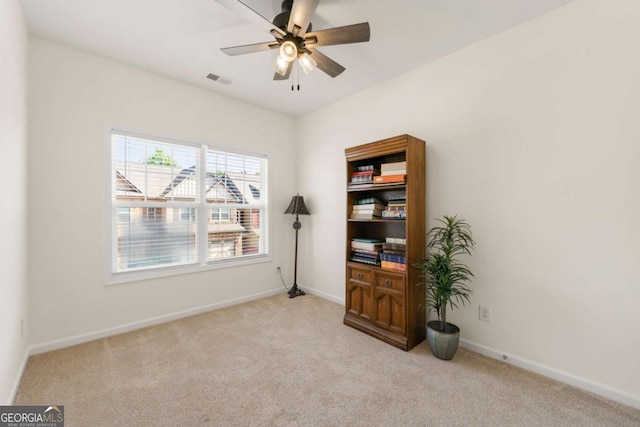 empty room featuring light colored carpet and ceiling fan