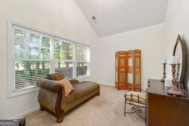 sitting room featuring high vaulted ceiling and light colored carpet