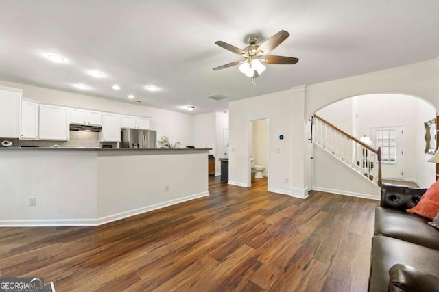 unfurnished living room with ceiling fan and dark hardwood / wood-style flooring