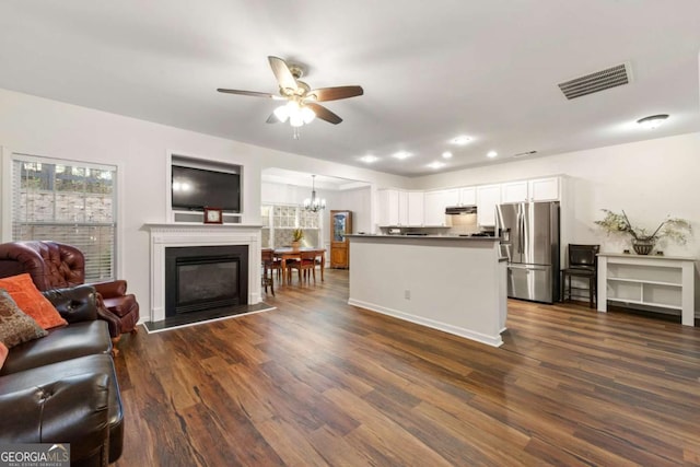 kitchen with pendant lighting, white cabinetry, dark hardwood / wood-style floors, stainless steel refrigerator with ice dispenser, and ceiling fan with notable chandelier