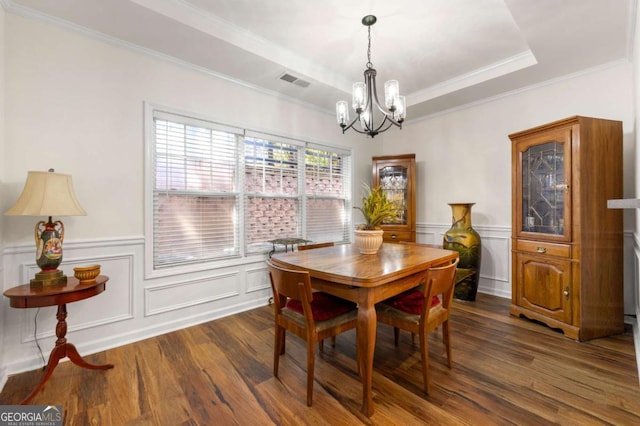 dining area with crown molding, a notable chandelier, dark hardwood / wood-style floors, and a raised ceiling