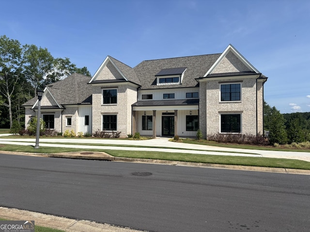 2819 Kestrel Dr, Statham, GA 30666 - view of front of home with a front lawn, board and batten siding, a standing seam roof, brick siding, and a metal roof