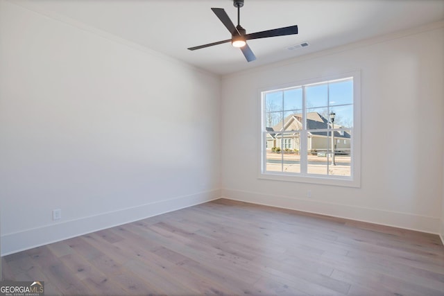 spare room featuring ceiling fan, ornamental molding, and light hardwood / wood-style flooring