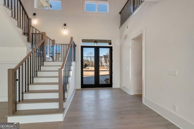 foyer with french doors, hardwood / wood-style floors, and a high ceiling