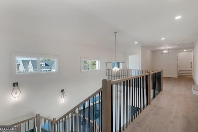 hall featuring light hardwood / wood-style flooring and a chandelier