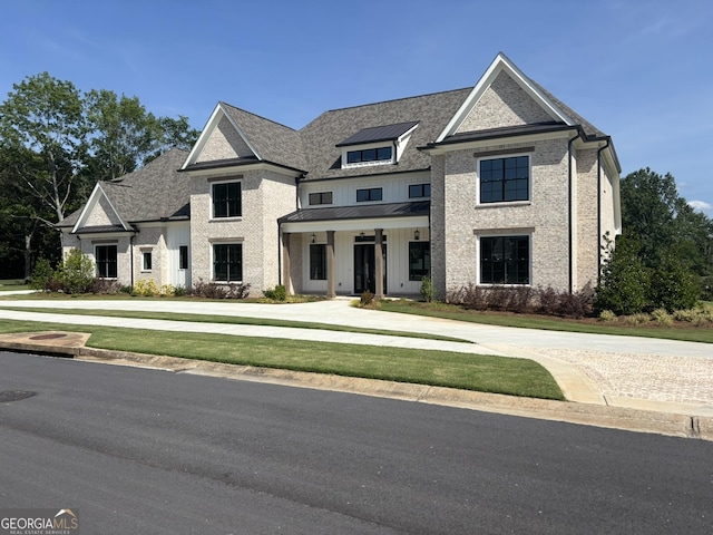 2819 Kestrel Dr, Statham, GA 30666 - view of front of property featuring a standing seam roof, brick siding, a front yard, and a metal roof