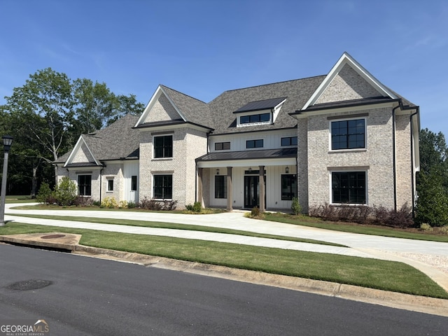 2819 Kestrel Dr, Statham, GA 30666 - view of front of house featuring board and batten siding, a standing seam roof, a metal roof, and brick siding