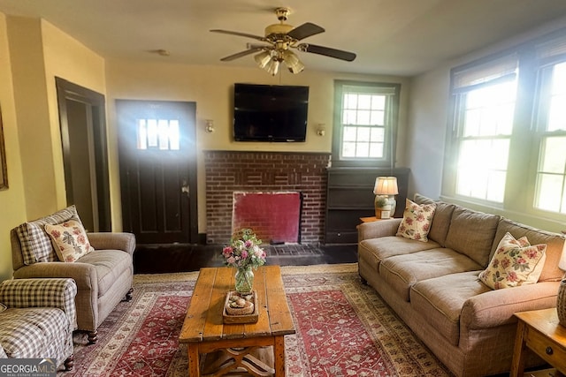 living room featuring a brick fireplace and ceiling fan