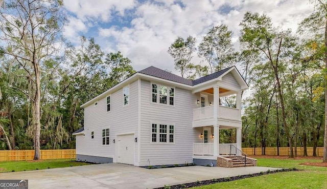 rear view of house with a garage and a balcony