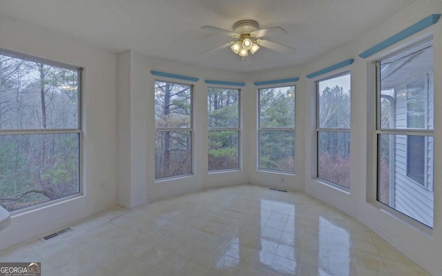 unfurnished sunroom with ceiling fan