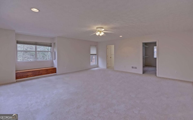 empty room featuring light colored carpet and ceiling fan