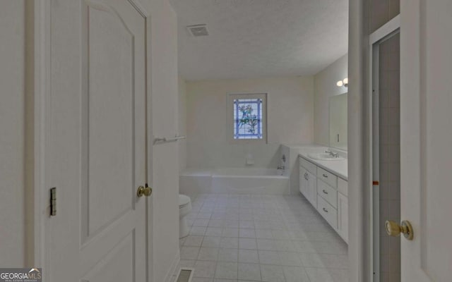 bathroom with a bathtub, vanity, a textured ceiling, tile patterned floors, and toilet