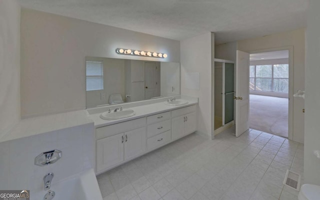 full bathroom featuring toilet, vanity, shower with separate bathtub, and a textured ceiling