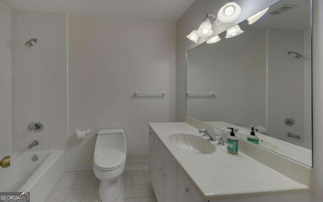 full bathroom featuring vanity, tiled shower / bath, tile patterned floors, and toilet