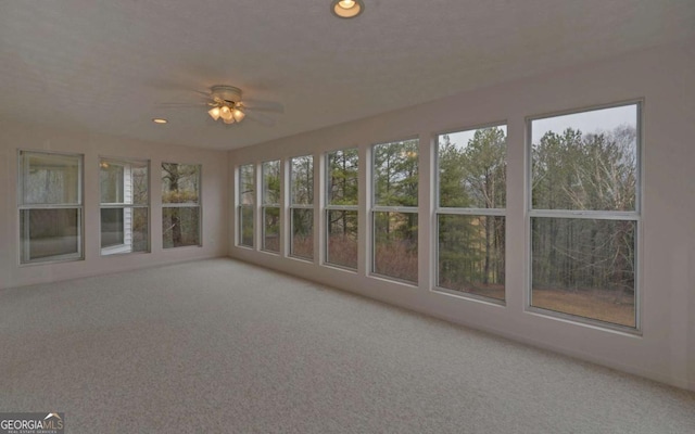 unfurnished sunroom with a healthy amount of sunlight and ceiling fan