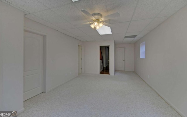 spare room featuring ceiling fan, light colored carpet, and a drop ceiling