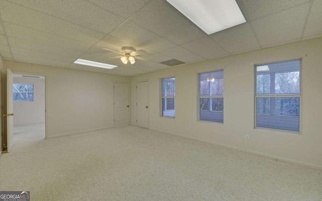 spare room featuring ceiling fan, a paneled ceiling, and light carpet