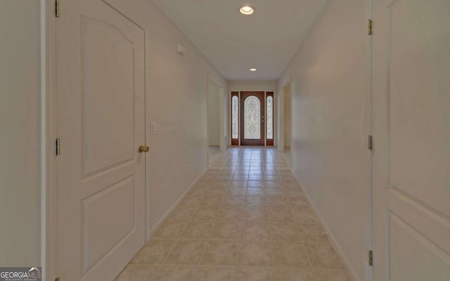 corridor featuring light tile patterned floors and french doors