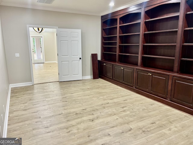 spare room with baseboards, light wood finished floors, visible vents, and crown molding