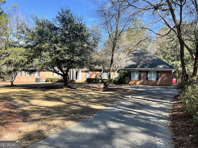 view of front of home featuring driveway and brick siding