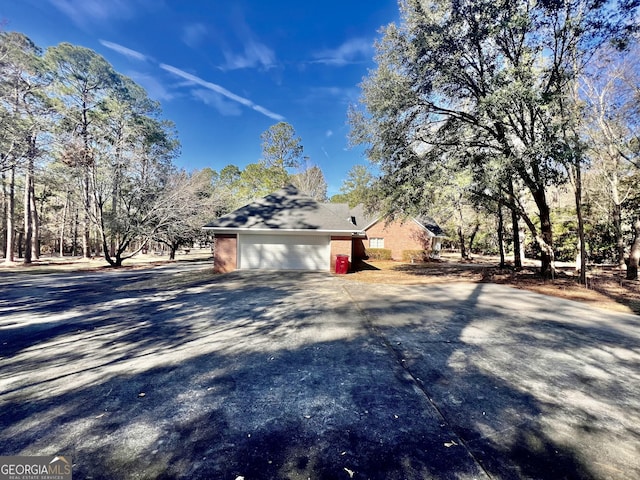 view of home's exterior featuring driveway, a garage, and brick siding