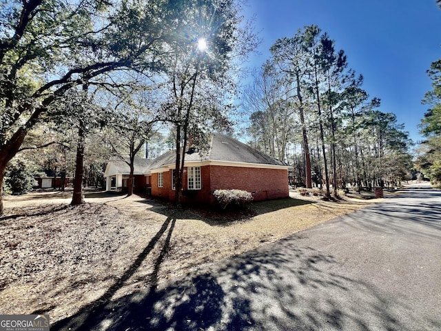 view of side of home with driveway and brick siding