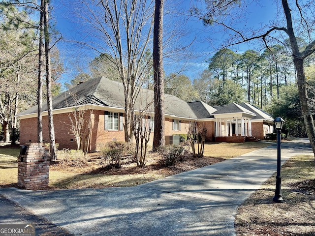 view of front of property with crawl space, concrete driveway, and brick siding