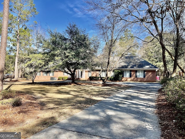 view of front of property featuring driveway and brick siding