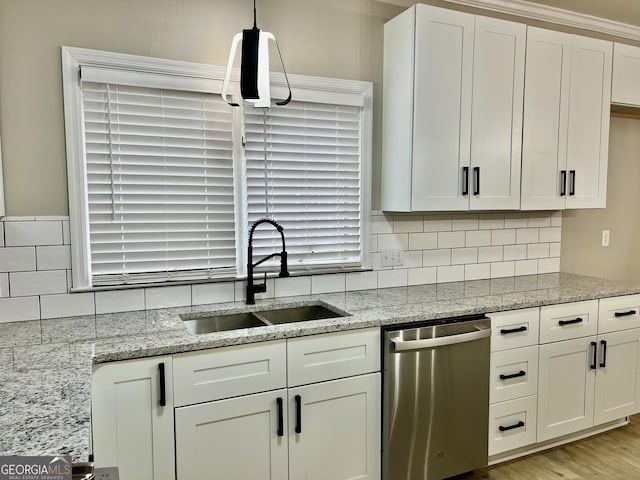 kitchen with decorative light fixtures, backsplash, white cabinets, a sink, and dishwasher