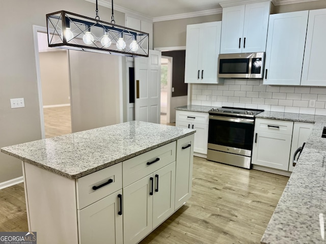 kitchen with appliances with stainless steel finishes, white cabinetry, decorative light fixtures, and light stone countertops