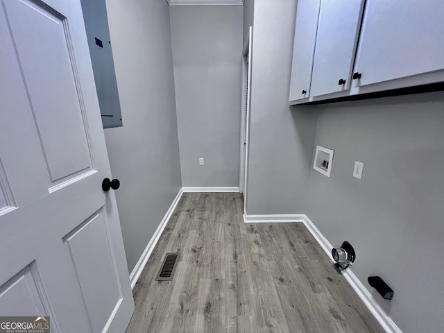 laundry room featuring hookup for a washing machine, light wood-style flooring, visible vents, baseboards, and cabinet space