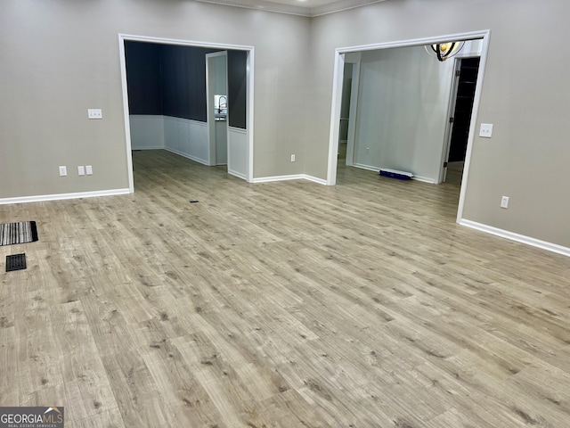 empty room featuring baseboards and light wood finished floors