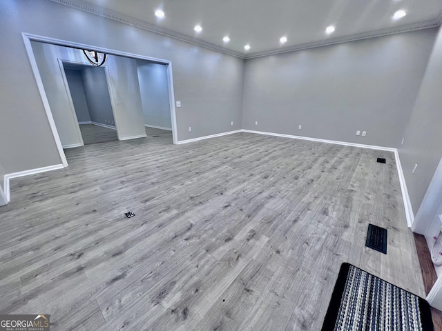 below grade area with baseboards, crown molding, and light wood finished floors