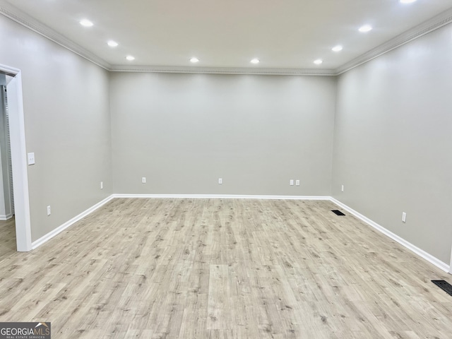 empty room with light wood finished floors, baseboards, visible vents, ornamental molding, and recessed lighting