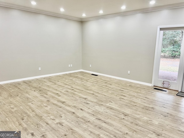 empty room featuring visible vents, baseboards, light wood-style flooring, ornamental molding, and recessed lighting